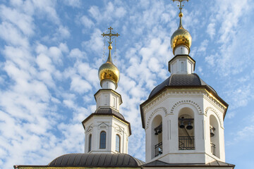 Golden domes of an Orthodox church on a sunny Easter day against the blue sky.