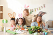 © Pixel-Shot - Little children in bunny ears making Easter crafts at table