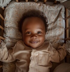 Wall Mural - African baby lies in a crib and smiles