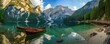 view on Lake Braies, Pragser Wildsee, Dolomites mountains, Sudtirol, Italy in Summer during the day with a boat on the lake.