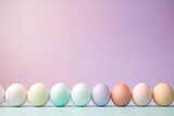 Fototapeta  - ligne d'œufs délicatement colorés à l'encre pour préparer les œufs décorés de Pâques. vieille tradition de la fin du carême chrétien. Fond violet et vert avec espace négatif pour texte copyspace