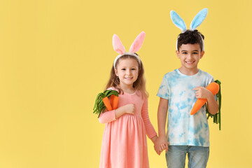 Sticker - Cute little children in bunny ears with toys carrots on yellow background. Easter celebration