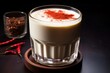 Glass filled with chilled espresso and milk, garnished with a slice of red chili pepper for a spicy twist.