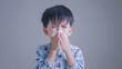 boy sneezing to tissue, he have a cold
