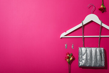 Wall Mural - Female accessories, hanger and flowers on pink background, space for text