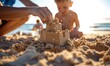 © piai - A child's hand building a sandcastle. Family beach vacation