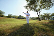 © DragonImages - Sportswoman standing on meadow and stretching out arm when practicing taekwondo stance