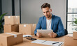 © Maksim Kostenko - Entrepreneur Small Business man works at home using laptop for commercial checking, online marketing, packing boxes, e-commerce, online sales