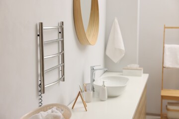 Poster - Heated towel rail on white wall in bathroom