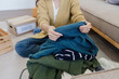 © itchaznong - Young Asian women sit in living room sorting clothes for donation in a donation box second hand clothes