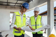 © itchaznong - Two Specialists Inspect Commercial, Industrial Building Construction Site. Real Estate Project with Civil Engineer
