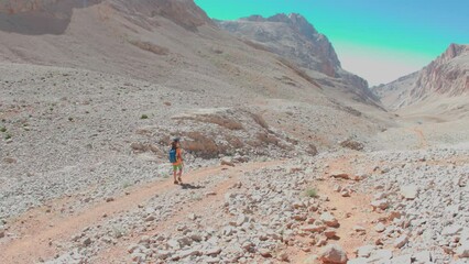 Wall Mural - adventure and trekking in the mountains. hiking with a backpack. a boy with a backpack walks along a path in the mountains. children's holidays in nature. Rock climbing and mountaineering concept.