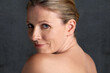 © Duncan M/peopleimages.com - Mature woman, studio and nude for beauty, skincare and portrait look in happy body care. Anti wrinkle female person, face and cosmetic in grey background, skin and glow for feminine confidence