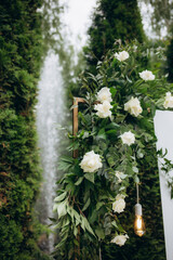 Wall Mural - A wedding arch decorated with a composition of fresh flowers for an outdoor wedding ceremony. Fashionable wedding decor.