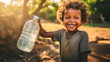 Poor, beggar, hungry smiling black child in Africa, thirsty to drink water from a plastic bottle.