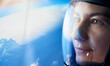 Close up view of woman in glassed space helmet against blue background