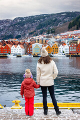 Wall Mural - A mother and her daughter enjoying the winter view of the cityscape of Bergen with Bryggen district, Norway