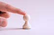 © Ari - Hand holding white chess pieces isolated on white, business strategy
