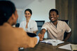 © bnenin - A black male doctor doing a handshake with a businesswoman from another company, having a meeting.