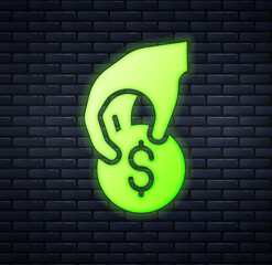 Poster - Glowing neon Hand holding casino chips icon isolated on brick wall background. Casino gambling. Vector