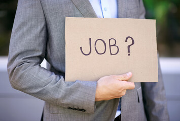 Hand, businessman and board for unemployed, jobless and poverty for adult, search or hunting for work. Economy, poor and male person as accountant showing sign on street in city of Cape Town