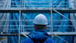 © katerinka - builder in a white helmet close-up against the background of a building under construction with space for text
