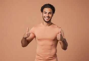 Wall Mural - A joyful man in a peach t-shirt gives double thumbs up. His bright smile and casual appearance suggest positivity and approachability.