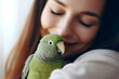 green parrot. a woman holding a green parrot. The bird appears healthy
