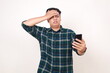 © ArvStd - Scared young asian man touching his head while holding a cell phone
