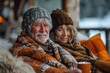 A portrait of a happy elderly couple cuddling under warm blankets with hot drinks, displaying affection and contentment