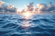 Serene and expansive ocean scene illuminated by the rising sun with textured clouds scattered across the sky