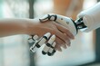 Human hand and robotic hand in handshake, symbolizing human-robot collaboration.