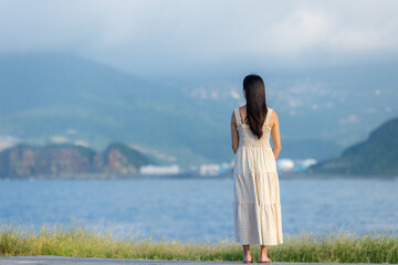 Wall Mural - Asian woman wear dress and look at the sea