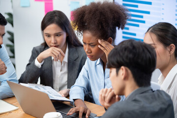 Wall Mural - Diverse businesspeople analyzing financial dashboard data on laptop in serious meeting, confused and worried. Difficult challenge in corporate world. Hectic analysis or problem in workplace. Concord