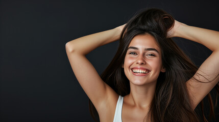Wall Mural - Close-up of an attractive girl with toothy smile staning at isolated dark background. Copy space. Studio shot.