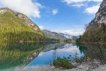 Wall Mural - beautiful landscape of mountain lake Braies in the Dolomites, Italy. Hiking trail along the lake and low clouds over the mountain