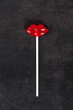 Red lips lollipop on a paper stick. Isomalt lollipops. Dark background