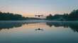 A single drone hovering above a serene lake at dawn reflecting on the water surface.