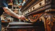 A craftsman meticulously restores details on classic wooden furniture