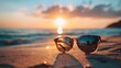 Sunglasses on Sandy Beach with Reflective Sunset and Waves