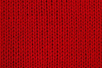 Red knitted fabric macro photo. Detail of clothes as a red background.