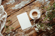 Blank white paper on wooden table with coffee cup and flowers