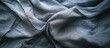 A black and white bed sheet made of grey cotton fabric is neatly stretched out, showcasing a stark contrast between the two colors.