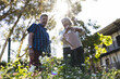© Wavebreak Media - Senior biracial woman and man are tending to garden flowers