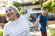 © Wavebreak Media - Senior biracial couple enjoys a playful moment outdoors, holding hands with joyful expressions