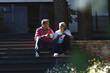 © Wavebreak Media - Senior biracial woman and biracial man sit on steps, enjoying a conversation with coffee