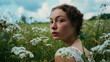Outdoor portrait of a beautiful woman looking backward over her shoulder while she walks through a field of flowers.