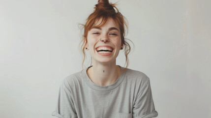 Sticker - A cheerful woman with red hair tied in a bun, laughing joyfully in a casual grey t-shirt, her freckles and bright expression conveying happiness.