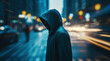 Unidentified man in a dark hoodie on a dark blurry city street