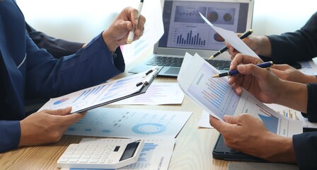 Close up of hands of business people working together in a conference room, brainstorming, discussing and analyzing and planning business strategies.